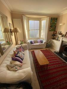 a living room with a white couch and a table at Delightful 2BD Cottage-Chic House Hammersmith! in London