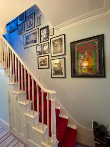 a staircase with a bunch of pictures on the wall at Delightful 2BD Cottage-Chic House Hammersmith! in London