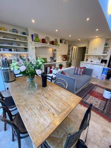 a living room with a wooden table and chairs at Delightful 2BD Cottage-Chic House Hammersmith! in London