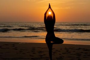 una mujer haciendo yoga en la playa al atardecer en Villas VR Beachwalk Avellanas, en Playa Avellana