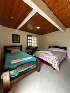 ein Schlafzimmer mit einem Bett und einer Holzdecke in der Unterkunft Finca La Toscana in Pereira