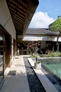 a courtyard with a pool and a house at Accessible Villa G in Sanur
