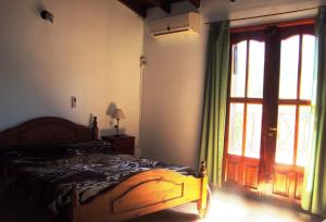 een slaapkamer met een bed en een schuifdeur bij Cabañas Wayramuyu in Merlo