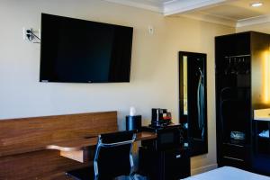 a room with a desk and a television on the wall at Greenwich Inn in San Francisco