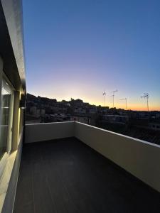 een balkon met uitzicht op de stad bij zonsondergang bij Il piacere appartaments in Caltagirone