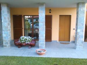 a front porch of a house with a pot of flowers at Appartamento con terrazza e giardino in Val d'Intelvi in Lanzo dʼIntelvi