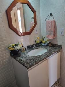 a bathroom with a sink and a mirror at Perfeita Cobertura no Flamengo in Rio de Janeiro