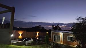 a house with two cars parked in the yard at night at ARI ALOJAMIENTOS in San Juan del Paraná