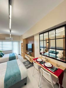 1 dormitorio con 2 camas y 1 mesa con 2 sillas en Manila Bay Retreat at Soleil Suite, en Manila