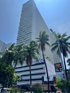 un edificio alto con palmeras delante en Manila Bay Retreat at Soleil Suite, en Manila