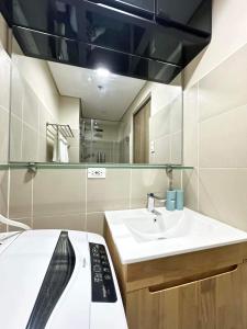 y baño con cama, lavabo y espejo. en Manila Bay Retreat at Soleil Suite, en Manila
