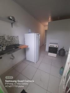 a white kitchen with a refrigerator and a stove at Apartamento em Muriqui - RJ - Apto. 202 in Mangaratiba