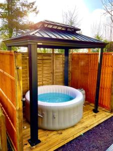 a hot tub in a gazebo on a deck at Rustic stone cottage with Hot Tub & fireplace in Crowborough