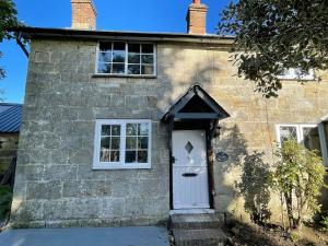 a brick house with a white door and windows at Rustic stone cottage with Hot Tub & fireplace in Crowborough