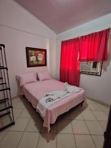 een slaapkamer met 2 bedden en een rood raam bij Casa Ili Guanacaste in Cartagena