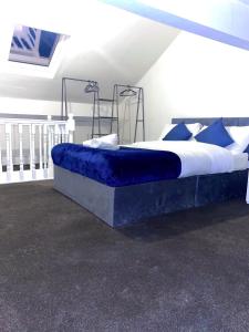 a bedroom with a large bed with blue sheets at Central 4 bedroom house in the heart of Birmingham city with Free Parking, and sleeps up to 8! in Birmingham