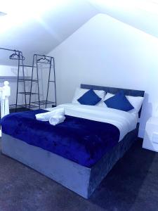 a bedroom with a bed with blue sheets and pillows at Central 4 bedroom house in the heart of Birmingham city with Free Parking, and sleeps up to 8! in Birmingham