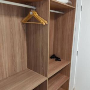 a wooden closet with wooden shelves and a hanger at Lindo apartamento na Barra in Salvador +1 photo