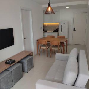 a living room with a couch and a dining room table at Lindo apartamento na Barra in Salvador