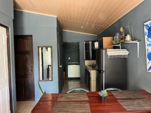 a kitchen with a table and a black refrigerator at Casa Ara Macao in Paquera