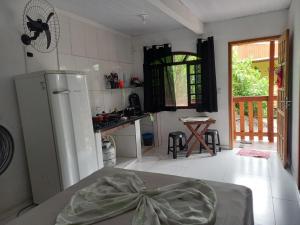 a kitchen with a refrigerator and a table in it at Pousada Beija Flor in Ilha do Mel