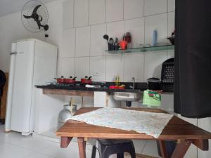 una pequeña cocina con mesa y nevera en Pousada Beija Flor en Ilha do Mel