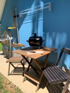 a toaster sitting on a picnic table next to two chairs at Meu Chalé in Miguel Pereira