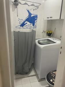 a bathroom with a dolphin shower curtain next to a toilet at Perfeita Cobertura no Flamengo in Rio de Janeiro