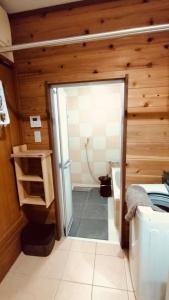 a bathroom with a shower and a glass door at ヴィラ結Miyakojima2 in Miyako Island