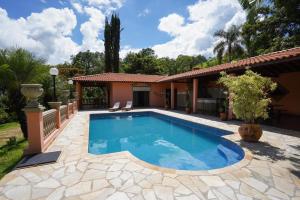 a swimming pool in front of a house at Espaço Villa Verde in Socorro
