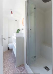 uma casa de banho branca com um chuveiro e um WC. em Somptueux appartement em Marselha