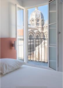 um quarto com uma janela com vista para uma catedral em Somptueux appartement em Marselha