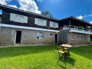 a house with a table in front of it at Nostra Casa Valletta in Campos do Jordão