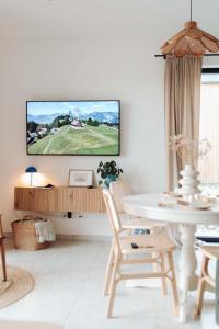 a living room with a tv on a white wall at Domki Ulkowo in Słajszewo