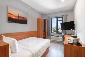 a hotel room with a bed and a television at Liberty View Brooklyn Hotel in Brooklyn