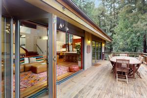 une maison dotée d'une terrasse avec une table et des chaises dans l'établissement Mindful Forest Sanctuary, à Mill Valley