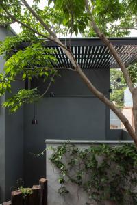 a house with a black wall and a tree at El Callejón Hotel Boutique in Oaxaca City