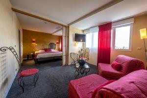 un salon avec un canapé rouge et une chambre dans l'établissement Best Western Adagio Saumur, à Saumur