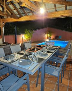 einen langen Tisch mit Stühlen und Weingläsern darauf in der Unterkunft Résidence Belle Anse 4 Pers 3ilets in Les Trois-Îlets