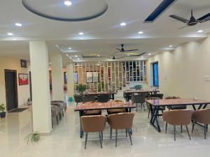 a restaurant with tables and chairs in a room at Hotel JCM Chintpurni in Bharwain