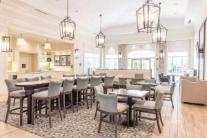 a restaurant with tables and chairs in a room at Homewood Suites by Hilton Palm Beach Gardens in Palm Beach Gardens