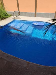 een groot zwembad van blauw water in een tuin bij Casa Ili Guanacaste in Cartagena