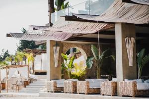 a resort with a bunch of chairs and umbrellas at Empire Beach Resort ADULTS ONLY in Dhërmi