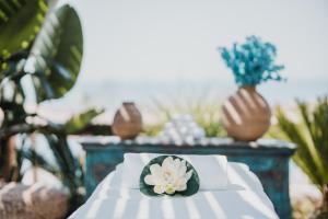 a white table with a flower on top of it at Empire Beach Resort ADULTS ONLY in Dhërmi