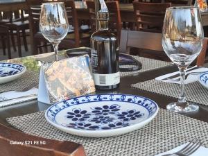 a bottle of wine and a plate on a table at Chácara Áquila in São Roque