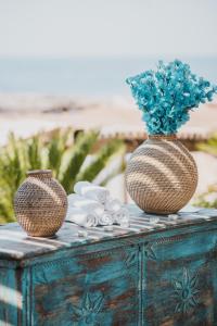 two vases sitting on top of a table with flowers at Empire Beach Resort ADULTS ONLY in Dhërmi