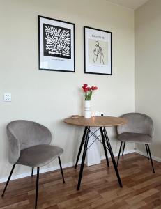 two chairs and a table with a vase of flowers at Elegant studio close to the city centre in Bratislava