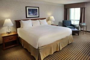 Pokój hotelowy z dużym łóżkiem i krzesłem w obiekcie Radisson Hotel Philadelphia Northeast w mieście Trevose