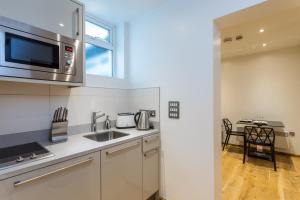 a kitchen with a sink and a microwave at Space ApartHotel in London