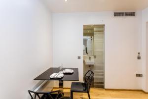 Un comedor con una mesa y sillas negras. en Space ApartHotel, en Londres 83 fotos más